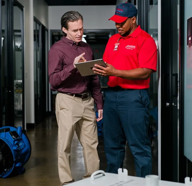 A Rainbow Restoration team member answers a question from a commercial restoration customer in Alvin, TX.