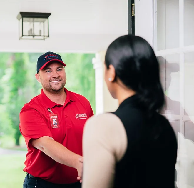 A Rainbow Restoration expert greets a Rainbow City, AL, homeowner in need of emergency restoration services at their front door. 