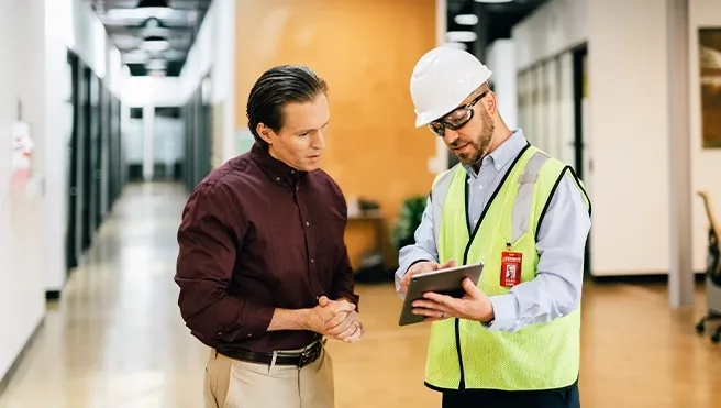 A Rainbow Restoration project manager discusses a property restoration project with a business owner in Duncan, SC.