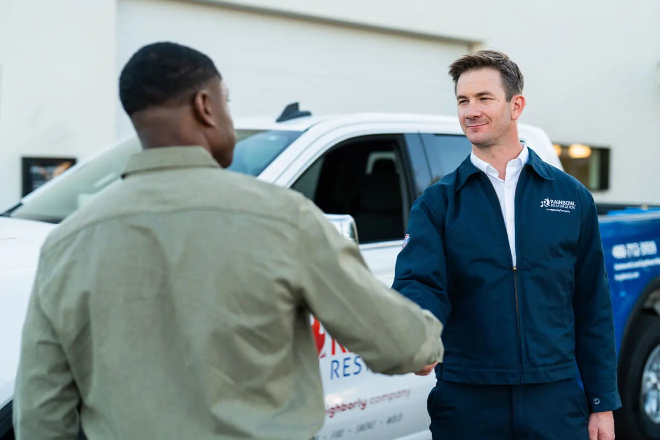 A Rainbow Restoration service professional greets a commercial client.