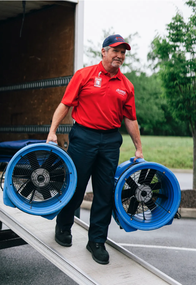 Rainbow Restoration service professional carrying commercial grade fans.