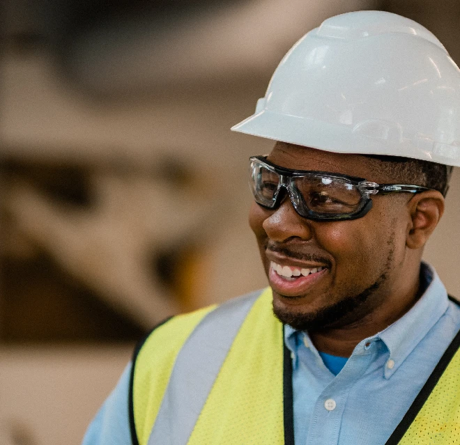 Smiling Rainbow Restoration technician wearing a hardhat and safety vest.