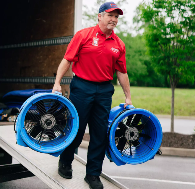 Rainbow Restoration service professional unloads equipment from vehicle. 