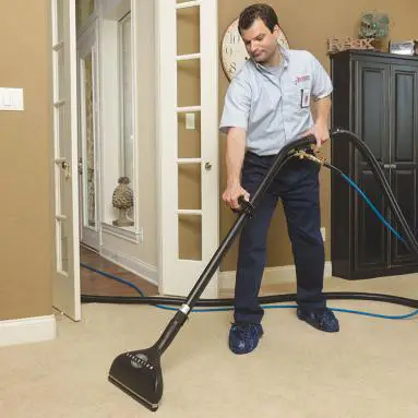 rbw man cleaning floor with vacuum cleaner.