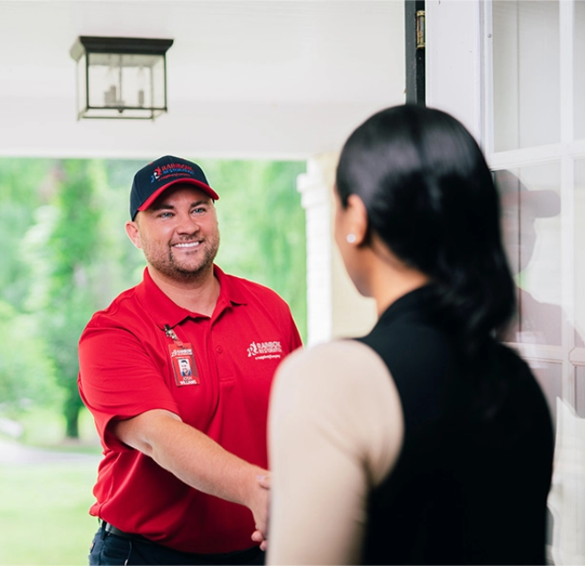 A Rainbow Restoration expert greets a homeowner in need of emergency restoration services at their front door.
