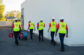 Rainbow Restoration professionals carrying water damage restoration equipment.