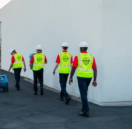 Rainbow Restoration professionals carrying water damage restoration equipment.