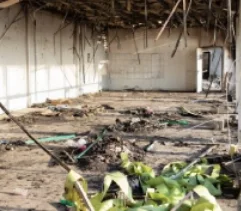 A room inside a building with extensive fire damage to the ceiling and floor.