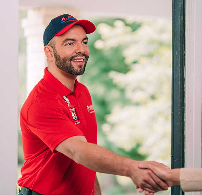 A Rainbow Restoration service professional shakes the hand of a homeowner as he arrives for water damage restoration. 