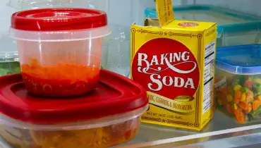 Baking soda and food in Tupperware inside a fridge