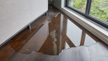 Water leaking and flooding a parquet wood floor.